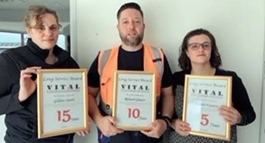 Long service award recipients holding 15, 10 and 5 year certificates
