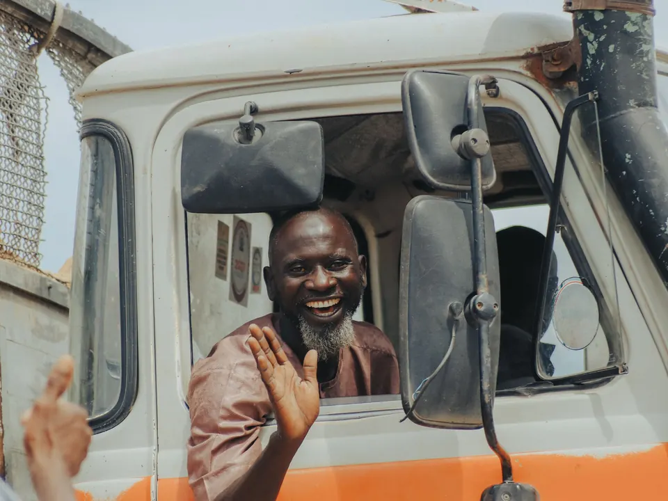Smiling truck driver waving from his cab