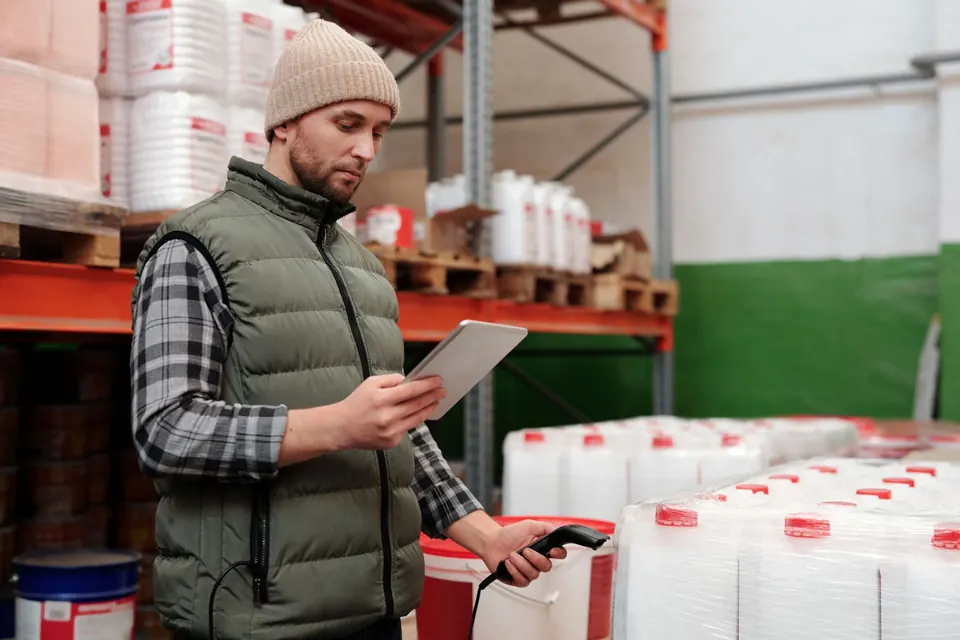 Warehouse controller checking inventory on a tablet